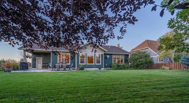 rear view of house featuring a yard, a patio area, and fence