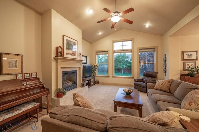 living room featuring baseboards, a tile fireplace, lofted ceiling, ceiling fan, and carpet flooring