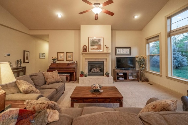 living room featuring carpet floors, a tile fireplace, ceiling fan, and lofted ceiling