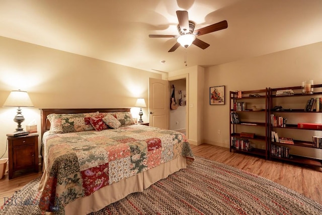 bedroom featuring ceiling fan, baseboards, and wood finished floors