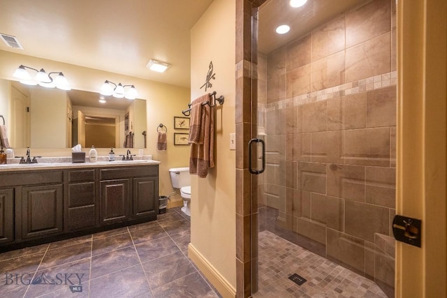 full bath with toilet, a sink, visible vents, double vanity, and a stall shower