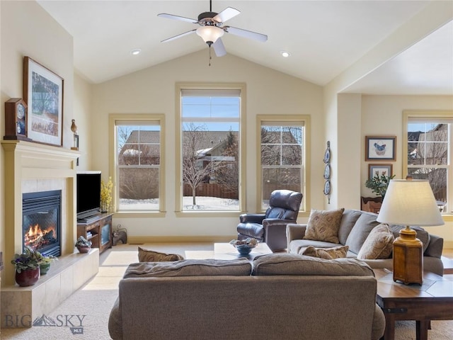 living room featuring lofted ceiling, a ceiling fan, a tiled fireplace, and recessed lighting