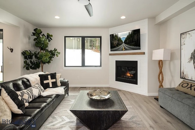 living area featuring recessed lighting, baseboards, wood finished floors, and a fireplace