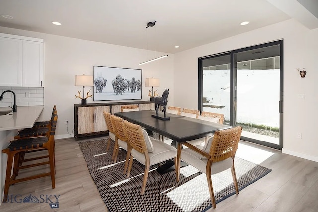 dining room with recessed lighting, light wood-type flooring, and baseboards