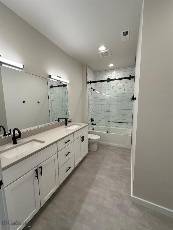 bathroom with enclosed tub / shower combo, toilet, visible vents, and a sink