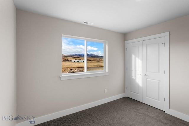 unfurnished bedroom featuring visible vents, a closet, baseboards, and carpet flooring