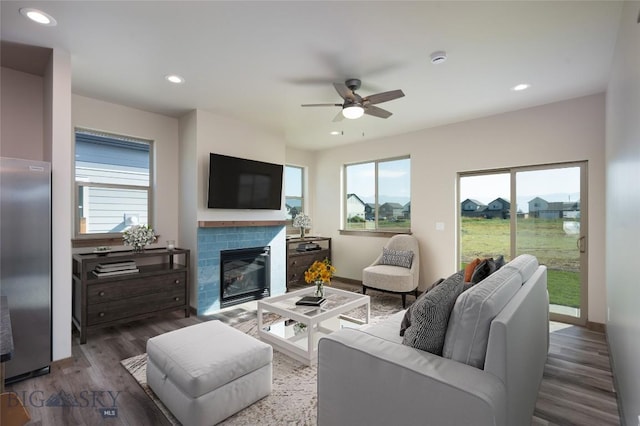 living room with a ceiling fan, recessed lighting, a glass covered fireplace, and wood finished floors