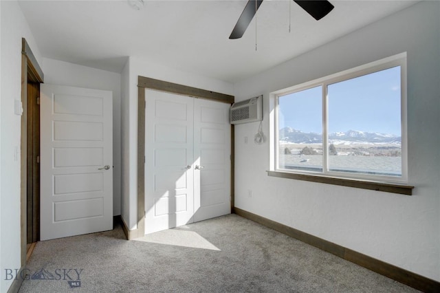 413 Garnier Ave Unit B, Livingston, MT 59047 - unfurnished bedroom with carpet, a wall unit AC, a closet, a ceiling fan, and baseboards