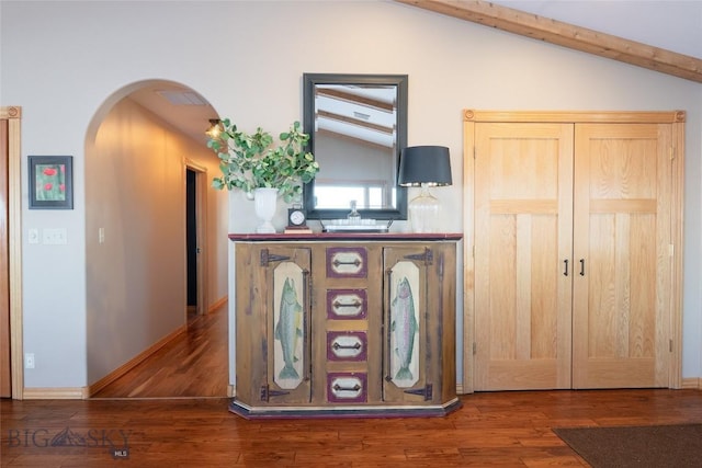 room details featuring arched walkways, baseboards, and wood finished floors