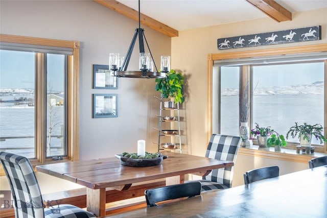 dining area featuring an inviting chandelier and lofted ceiling with beams