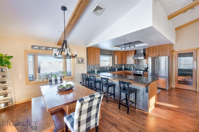 dining room with lofted ceiling with beams, visible vents, an inviting chandelier, and dark wood finished floors