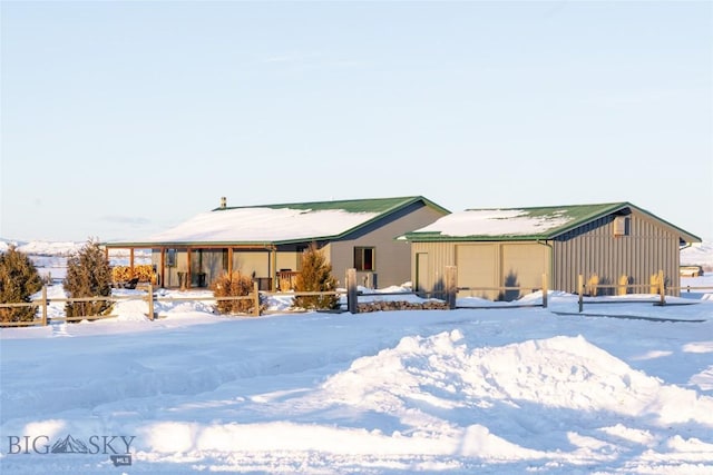 snow covered house featuring an attached garage and board and batten siding