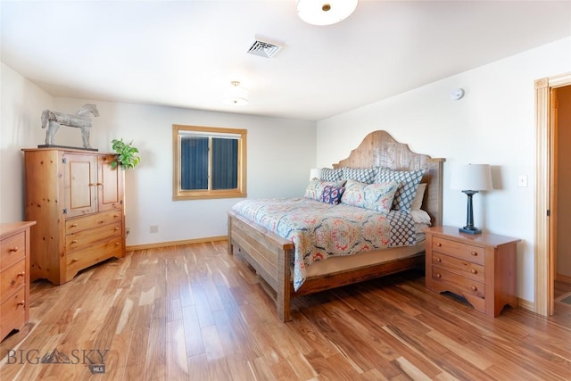 bedroom featuring baseboards, visible vents, and light wood finished floors