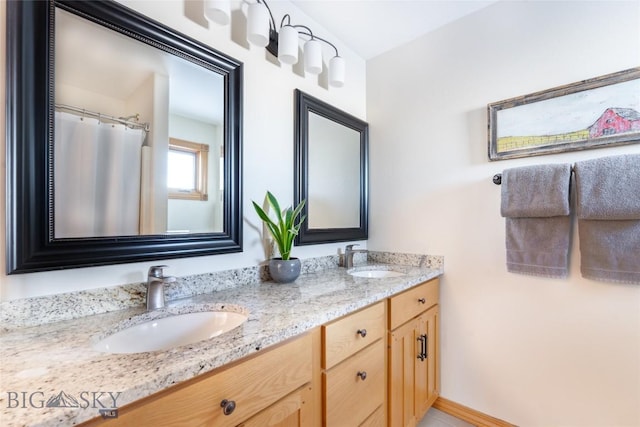 bathroom featuring double vanity, baseboards, and a sink