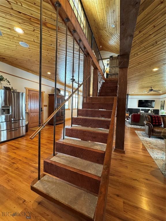 staircase featuring wood ceiling, ceiling fan, wood finished floors, and recessed lighting