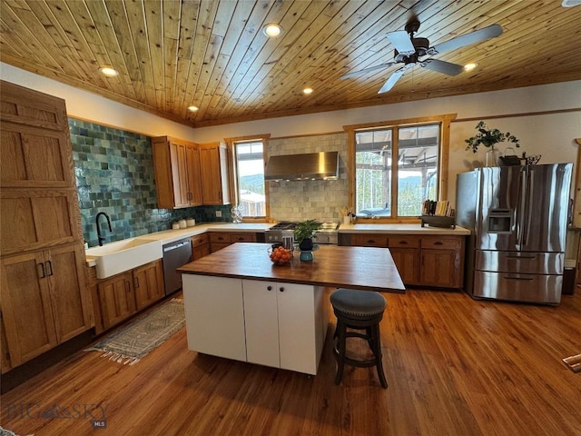 kitchen with extractor fan, stainless steel appliances, butcher block counters, a sink, and dark wood-style floors