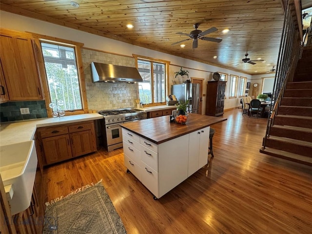 kitchen with wooden ceiling, stainless steel appliances, exhaust hood, wood counters, and light wood-style floors