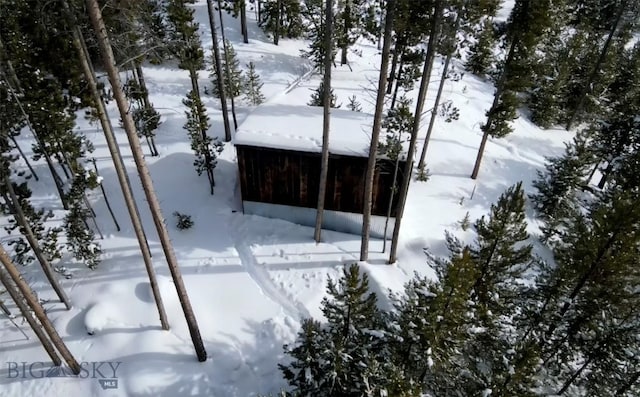 view of snowy exterior featuring a garage and a sunroom