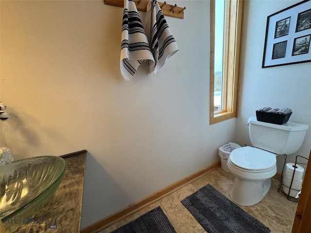 bathroom featuring baseboards and toilet