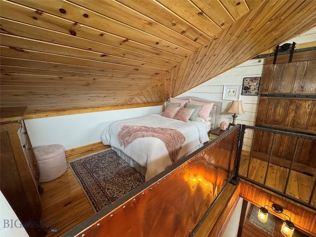 bedroom with lofted ceiling, wood ceiling, and wood finished floors