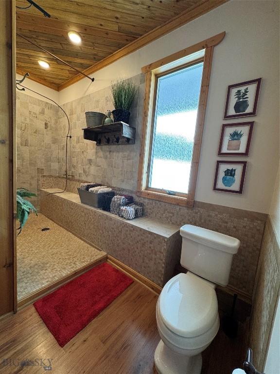 full bath featuring wooden ceiling, tile walls, tiled shower, and wood finished floors