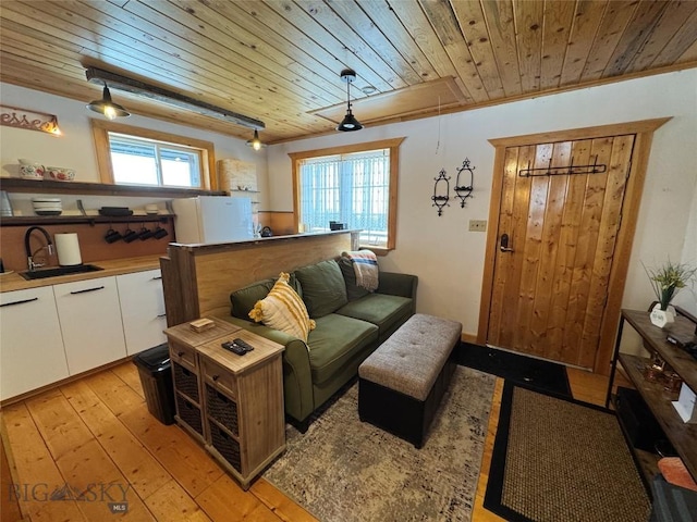 living room featuring wood ceiling, attic access, and light wood-style flooring