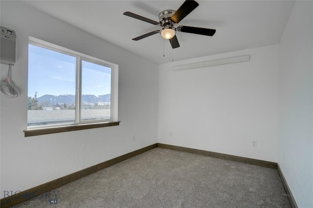 carpeted spare room with baseboards and a ceiling fan