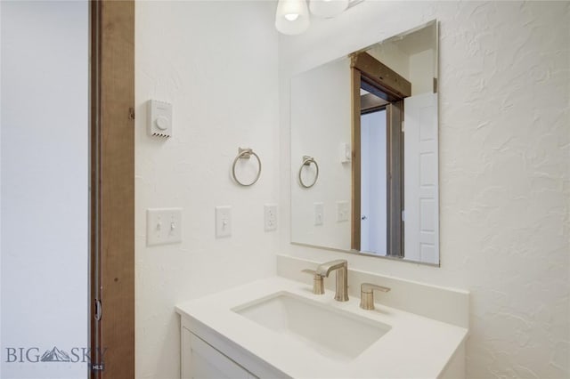 bathroom featuring a textured wall and vanity