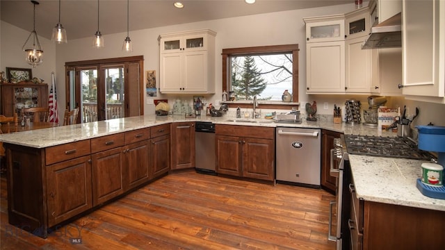 kitchen featuring dark wood finished floors, appliances with stainless steel finishes, a peninsula, ventilation hood, and a sink