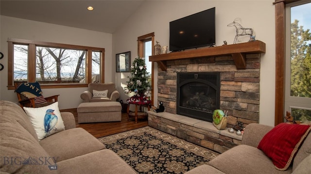 living room featuring recessed lighting, vaulted ceiling, wood finished floors, and a stone fireplace