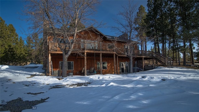 snow covered property featuring stairs