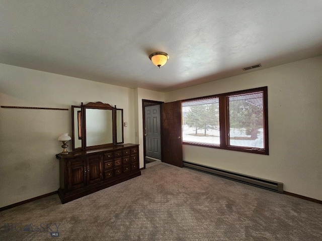 unfurnished bedroom with carpet floors, a baseboard radiator, visible vents, and baseboards