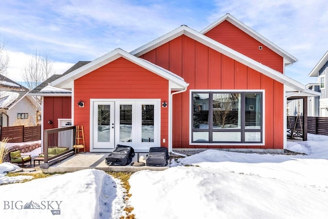 view of front of house featuring board and batten siding, french doors, and fence