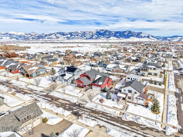 snowy aerial view featuring a residential view and a mountain view