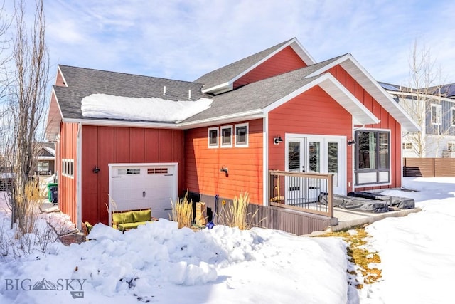 view of front of home with roof with shingles, board and batten siding, and an attached garage