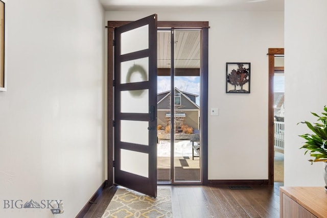 entryway with dark wood-type flooring and baseboards