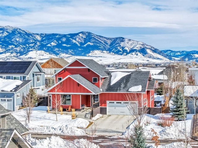 rustic home with a mountain view, a garage, concrete driveway, roof with shingles, and board and batten siding