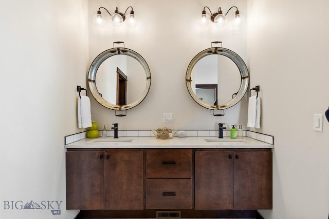 bathroom featuring double vanity, a sink, and visible vents