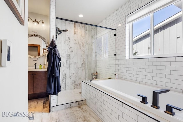 full bathroom with wood finished floors, tiled shower, a garden tub, and vanity