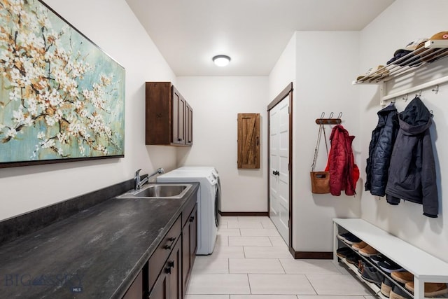 washroom featuring cabinet space, light tile patterned floors, baseboards, independent washer and dryer, and a sink