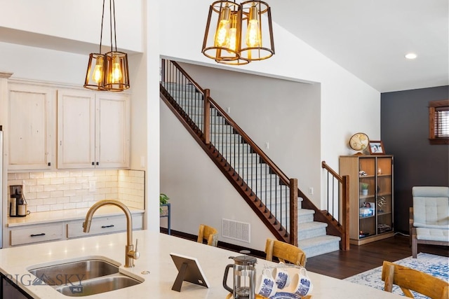 kitchen with visible vents, dark wood-style flooring, light countertops, pendant lighting, and a sink