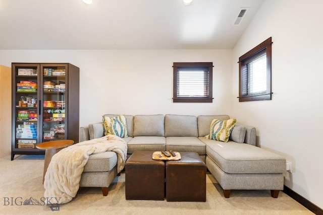 living area featuring light carpet, baseboards, and visible vents