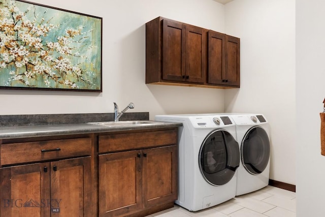 laundry area with light tile patterned floors, washer and clothes dryer, a sink, and cabinet space