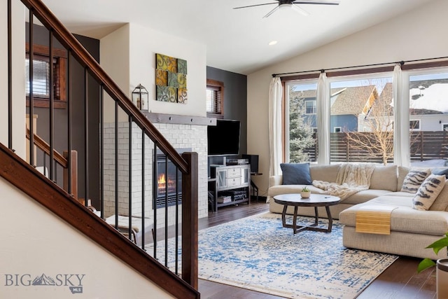 living area with vaulted ceiling, stairway, and wood finished floors