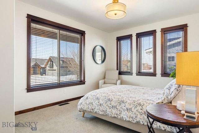 carpeted bedroom with baseboards, multiple windows, and visible vents