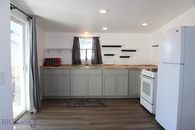 kitchen featuring white appliances, dark wood-type flooring, butcher block counters, a sink, and open shelves