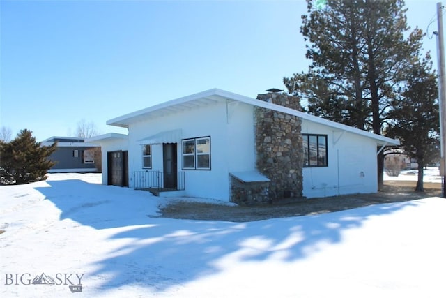 view of front of property featuring a chimney and stucco siding