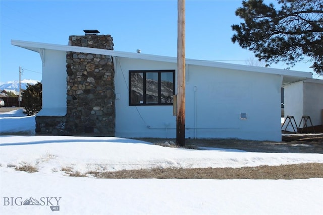 exterior space with a chimney and stucco siding