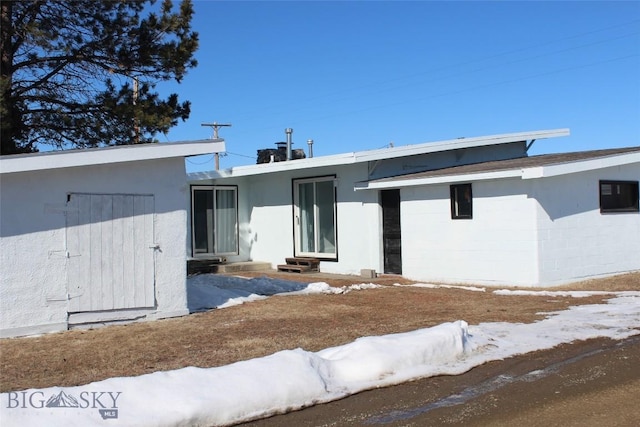 exterior space with entry steps, concrete block siding, and stucco siding