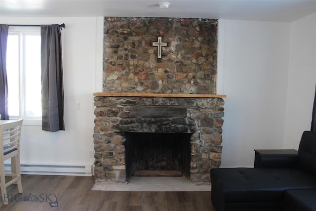 interior details featuring baseboard heating, a fireplace, and wood finished floors